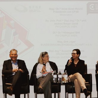 Frontalaufnahme der Podiumsdiskussion (von links nach rechts: Dipl.-Ing.in Susanne Formanek, Mag. Dirk Jäger, Mag.a Dr.in Irene Giner-Reichl, Ao. Univ. Prof.in Dipl.-Ing.in Dr.in phil. Andrea Rieger-Jandl, DI.in Dr.in Hildegard Sint)